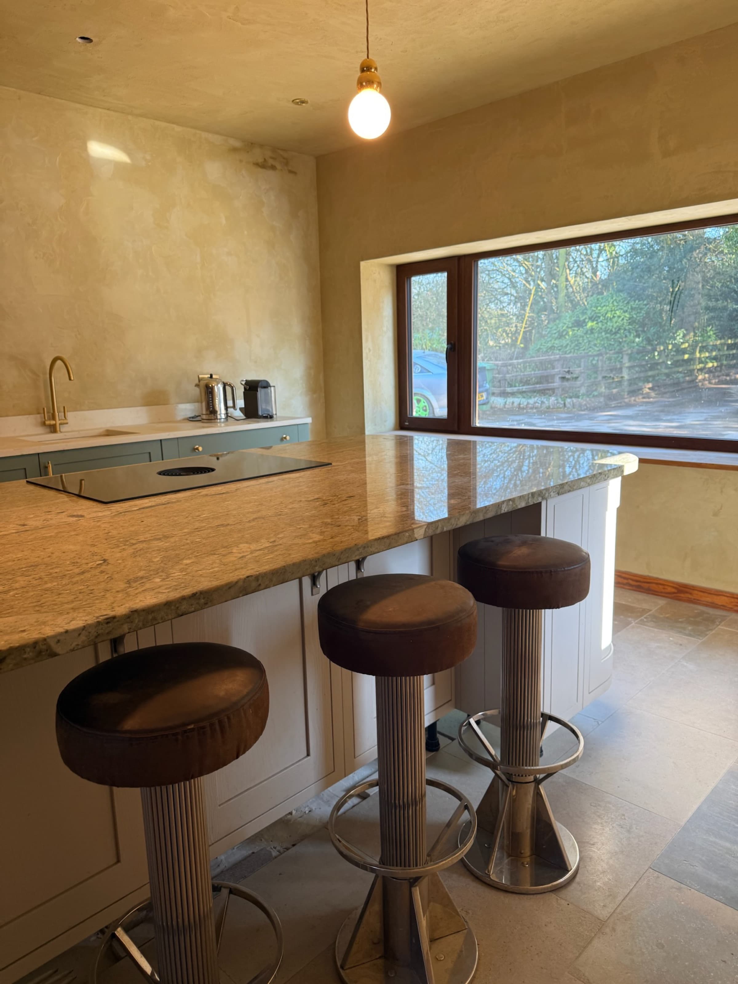 Kitchen island with marble worktop and bar stools